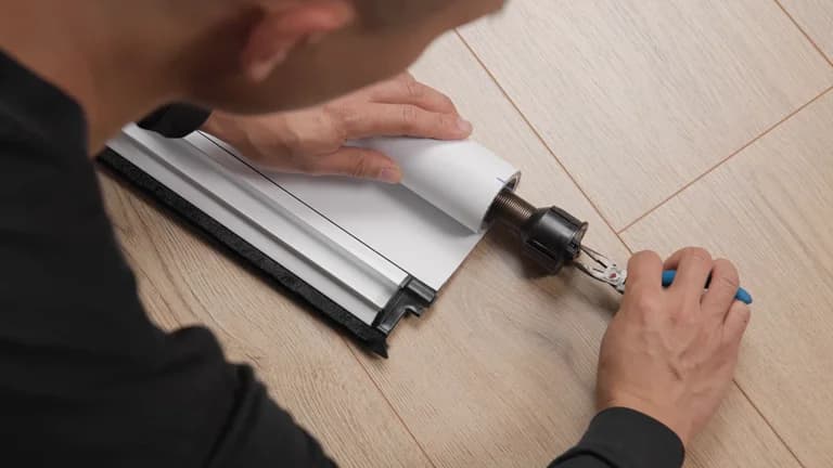 Pliers pinching the tab at the end of a fabric roll